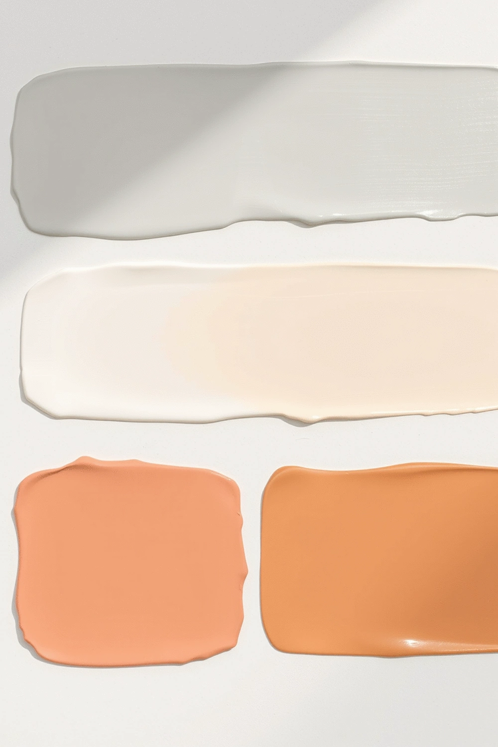 Paint swatches demonstrating different sheens from matte to high-gloss, arranged on a clean, light-colored surface.